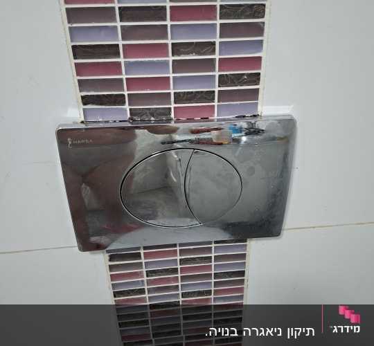 לחצן הדחה כסוף על רקע אריחים צבעוניים